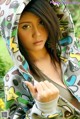 A woman in a hoodie is posing for a picture.